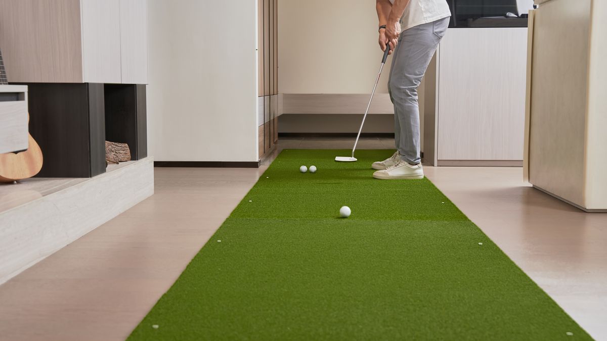 Golfer practising putts on an indoor green