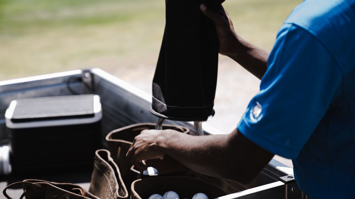 Golfer collecting practice balls before marking a card